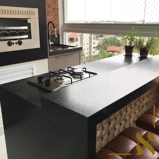 Ilha de granito preto com cooktop embutido e adega vazada sob a bancada