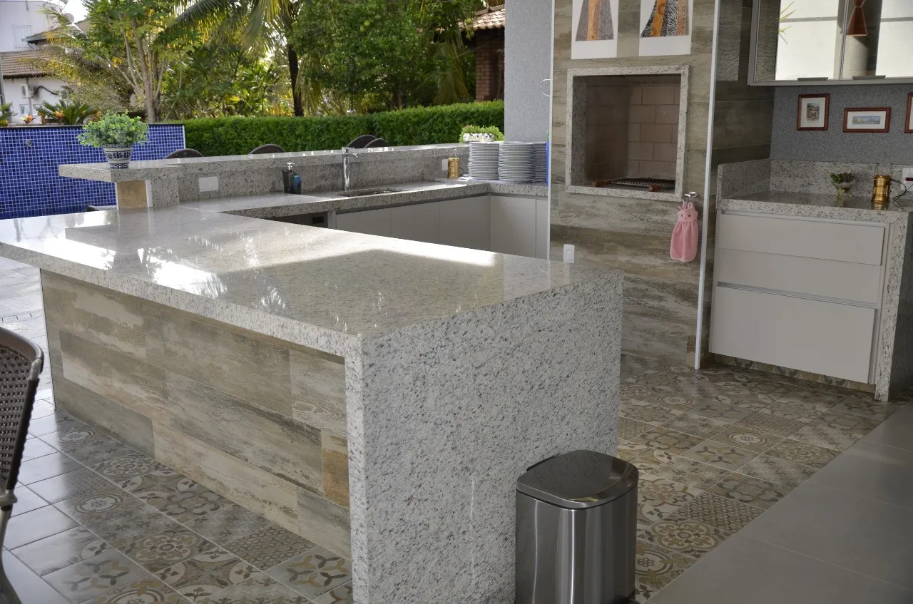 Bancada externa de granito claro com cuba embutida, em varanda gourmet