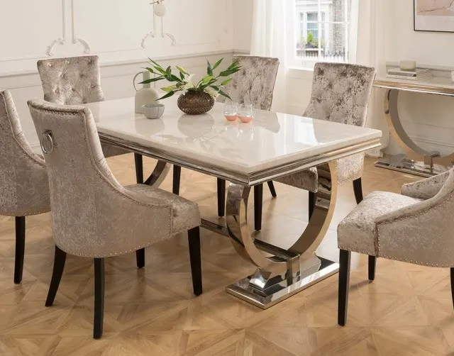 Sala de jantar com mesa de tampo de mármore claro e cadeiras estofadas